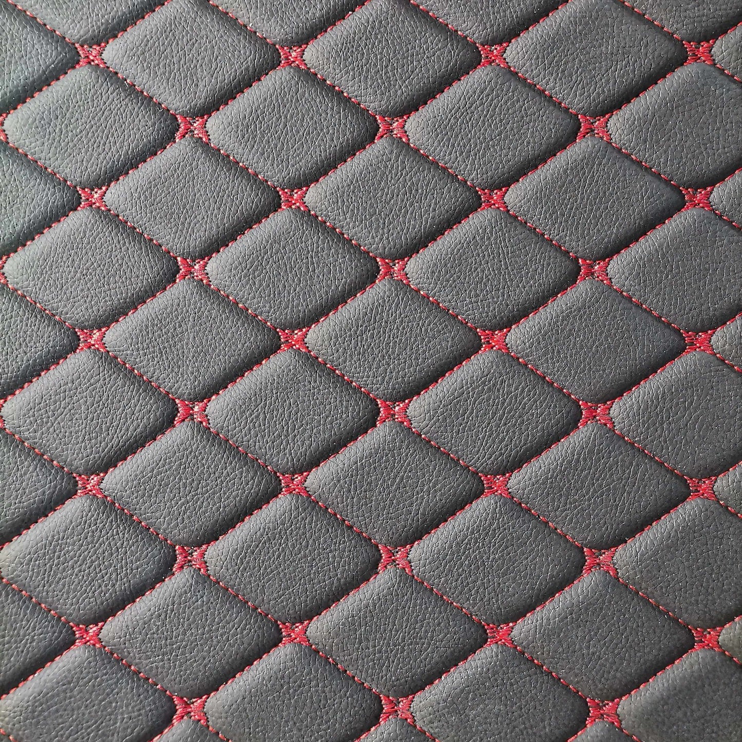 Close-up of Lux-Beautyplus™ diamond-stitched car mat with gray leather and red stitching details.