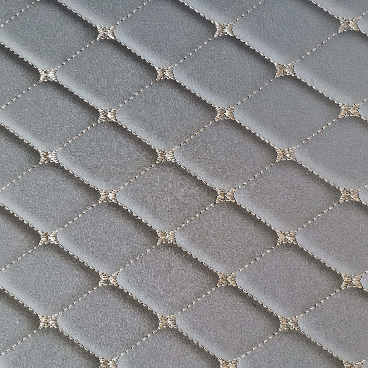 Close-up of diamond-stitched gray car mat surface, showcasing its durable and stylish design.