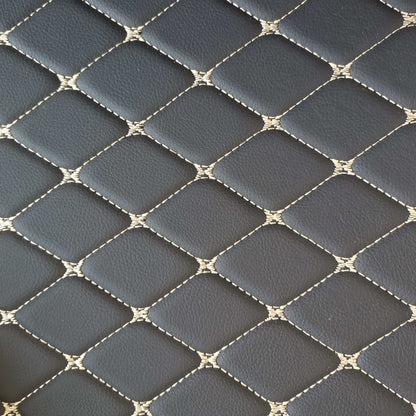 Close-up of diamond-stitched black car mat material with beige stitching for luxury car interiors.
