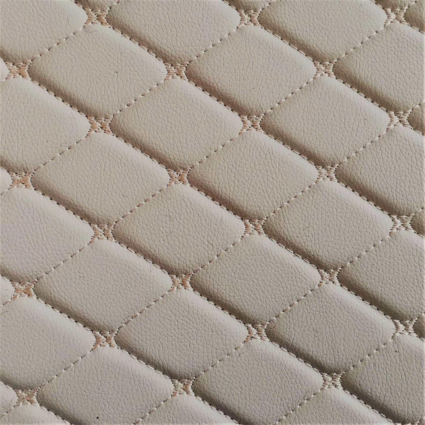 Close-up of a cream-colored diamond-stitched leather texture, ideal for car interiors and upholstery.